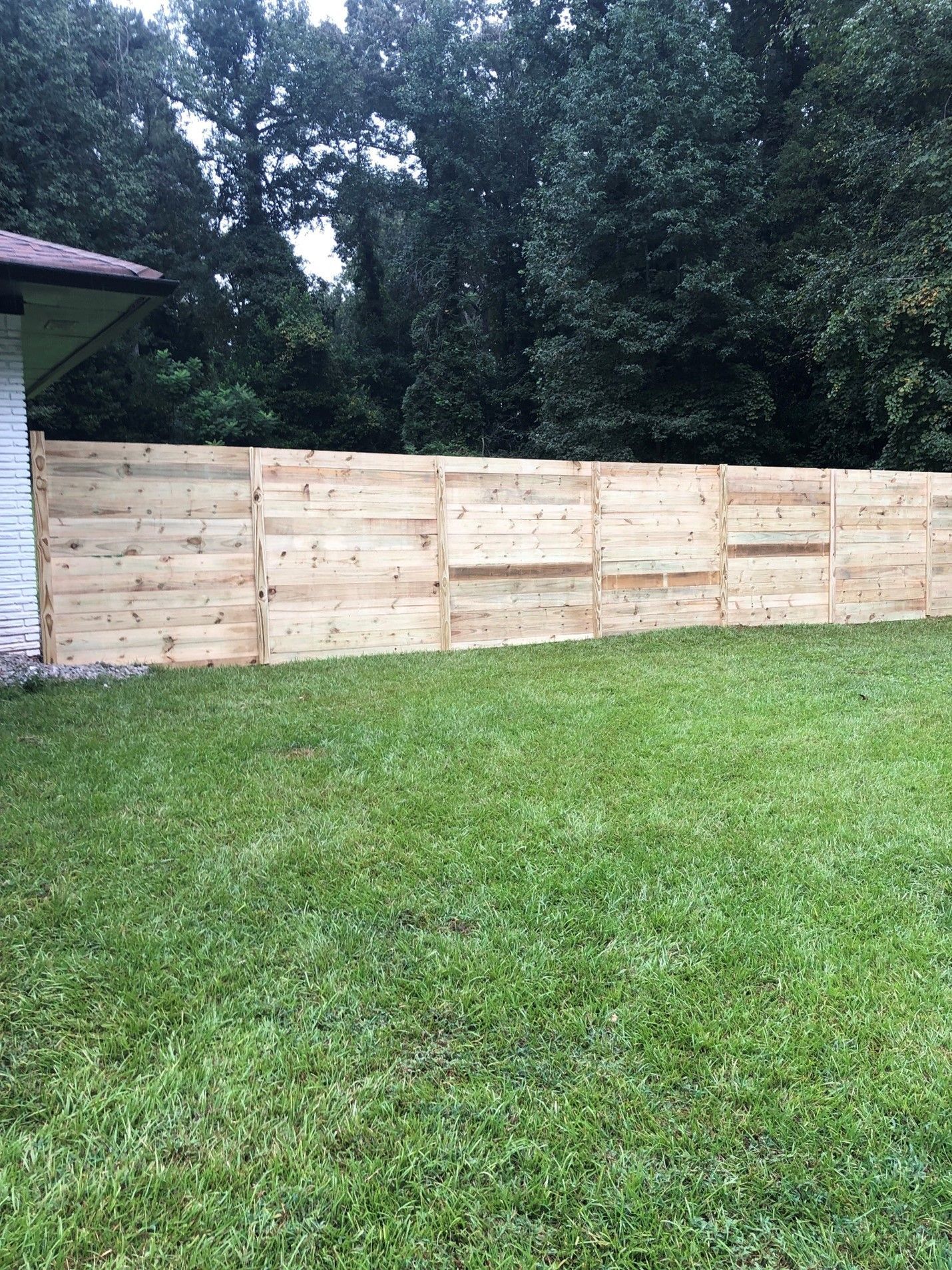 Wooden Fence In Middle Of Green Yard — Covington, GA — Barbara's Fence Company, Inc.