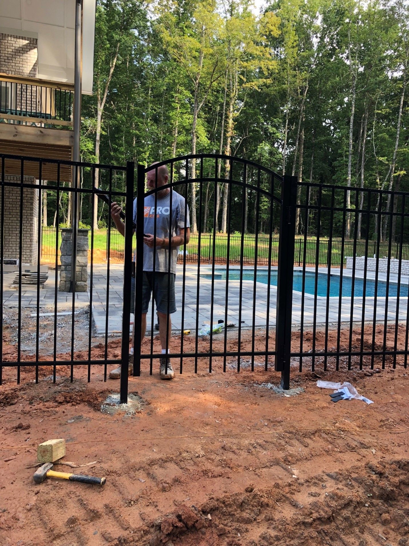 Picture Of Man Standing Behind Fence — Covington, GA — Barbara's Fence Company, Inc.