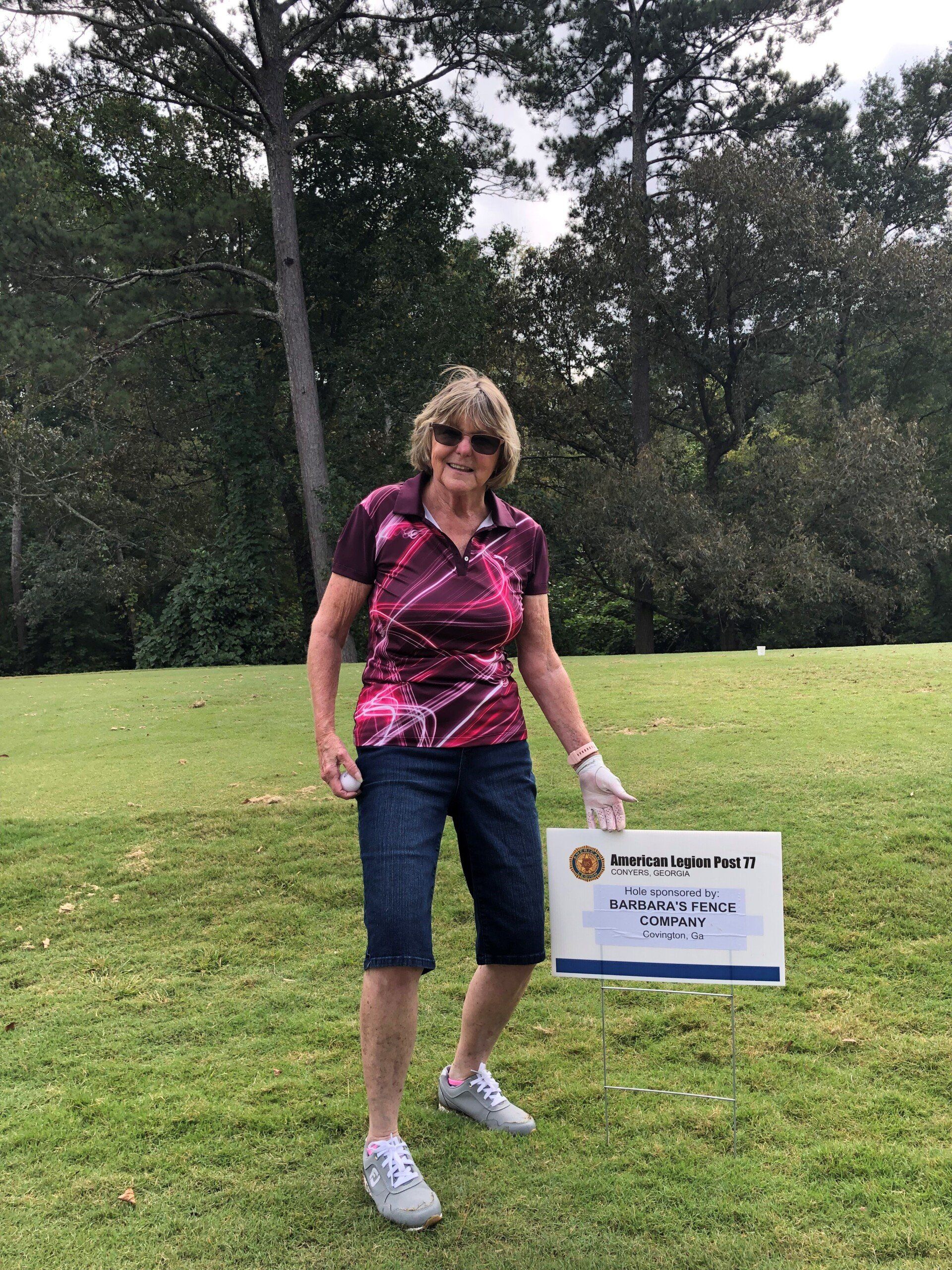 Woman In Front Of Sponsorship Sign — Covington, GA — Barbara's Fence Company, Inc.