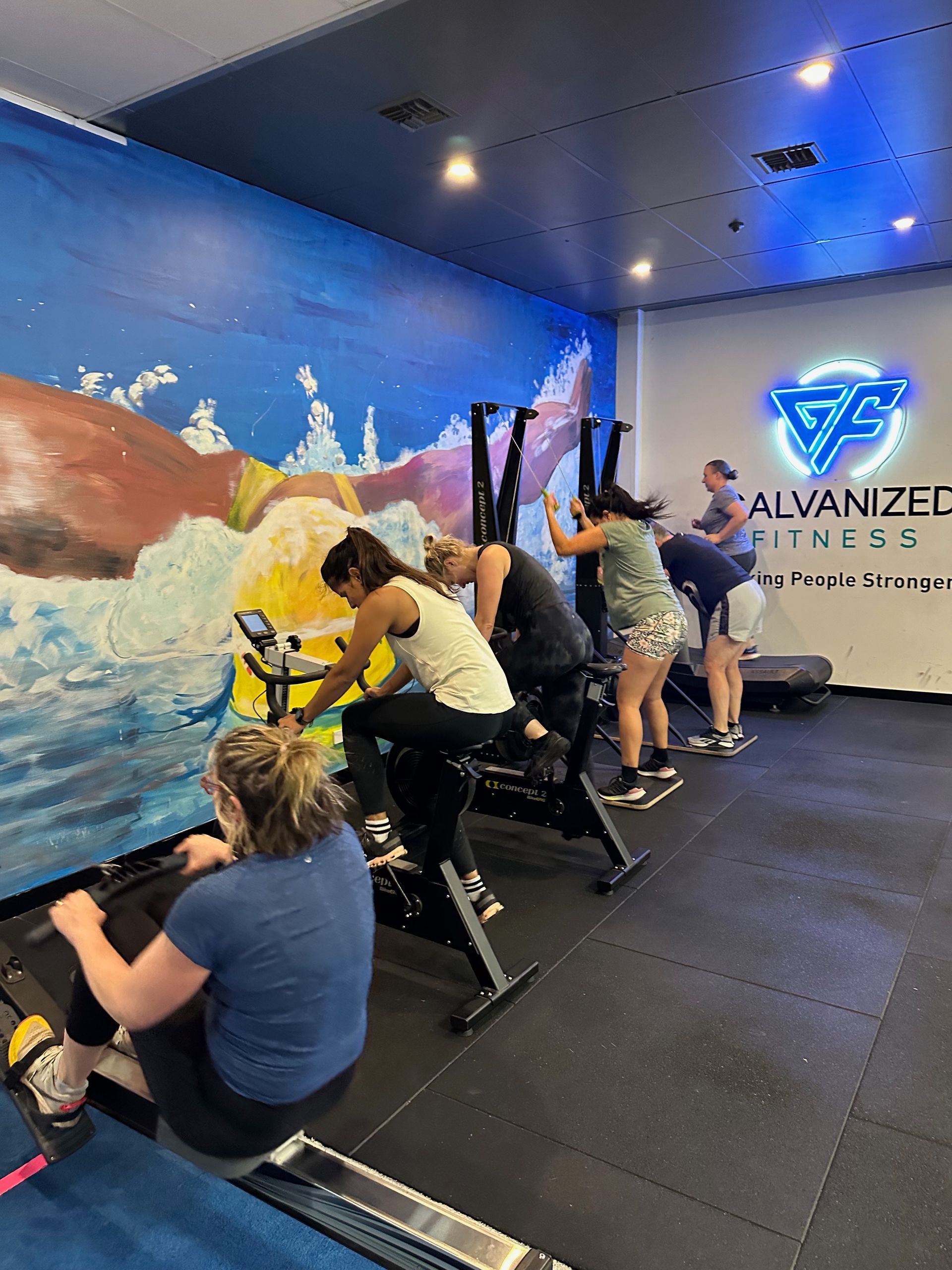 A group of people are riding exercise bikes in a gym.