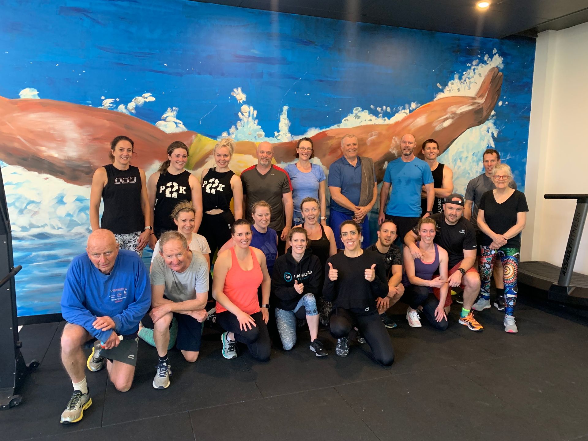 A group of people are posing for a picture in a gym.