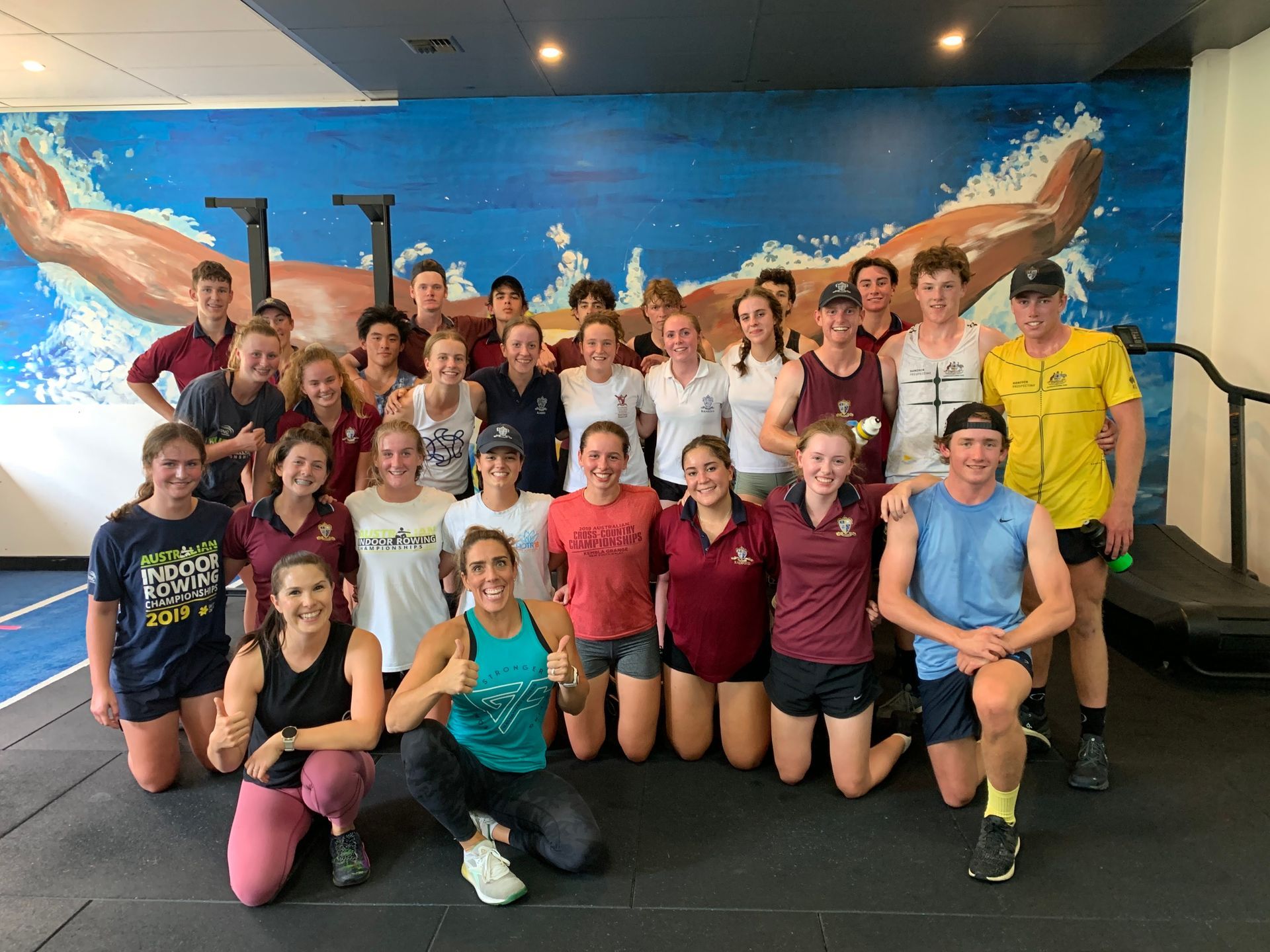 A group of people are posing for a picture in a gym.