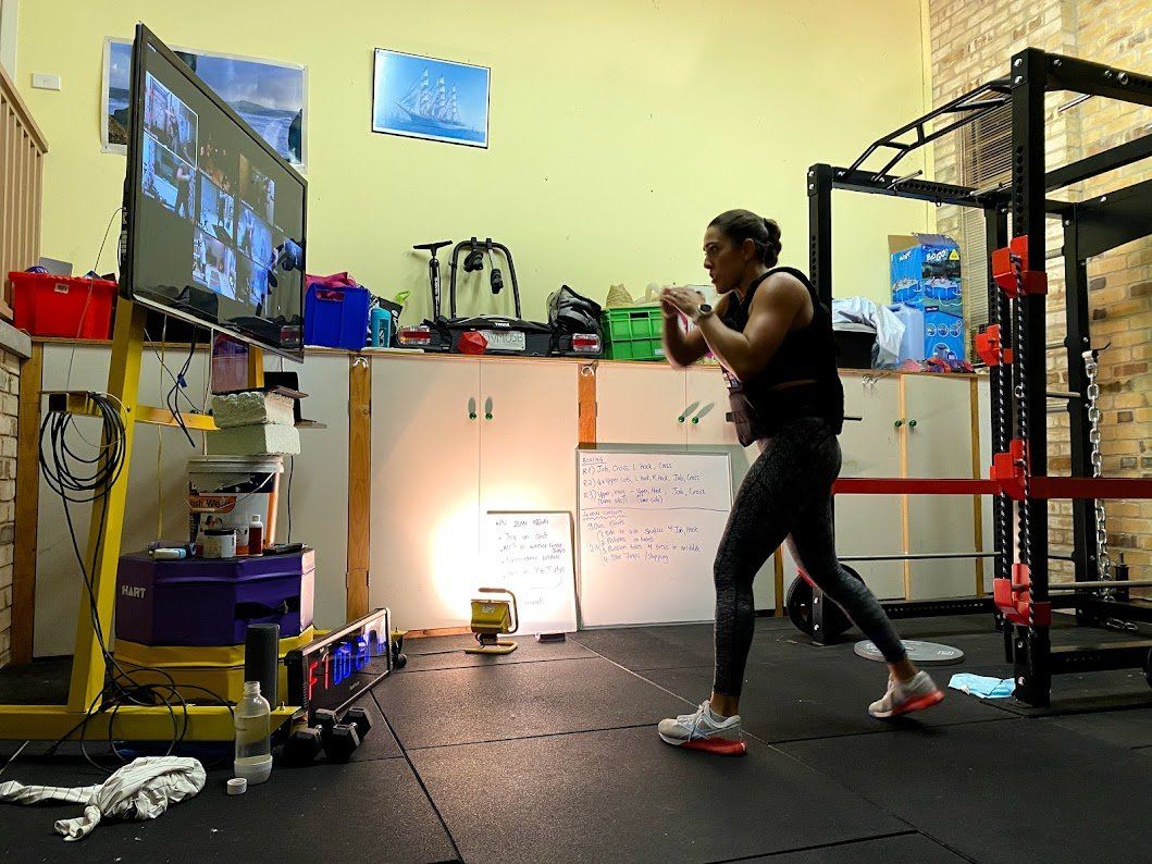 A man is boxing in a gym in front of a television.