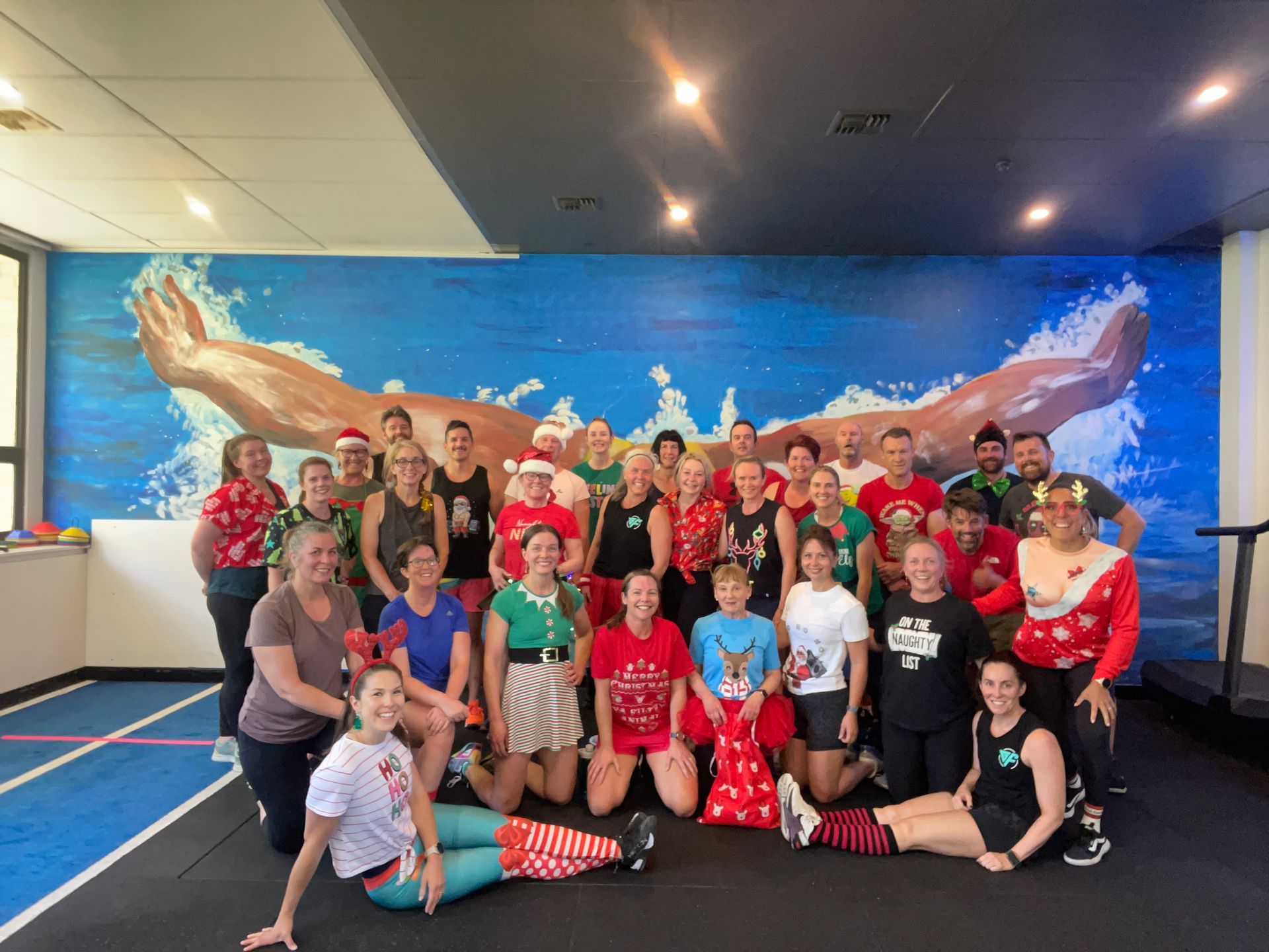A group of people are posing for a picture in a gym.