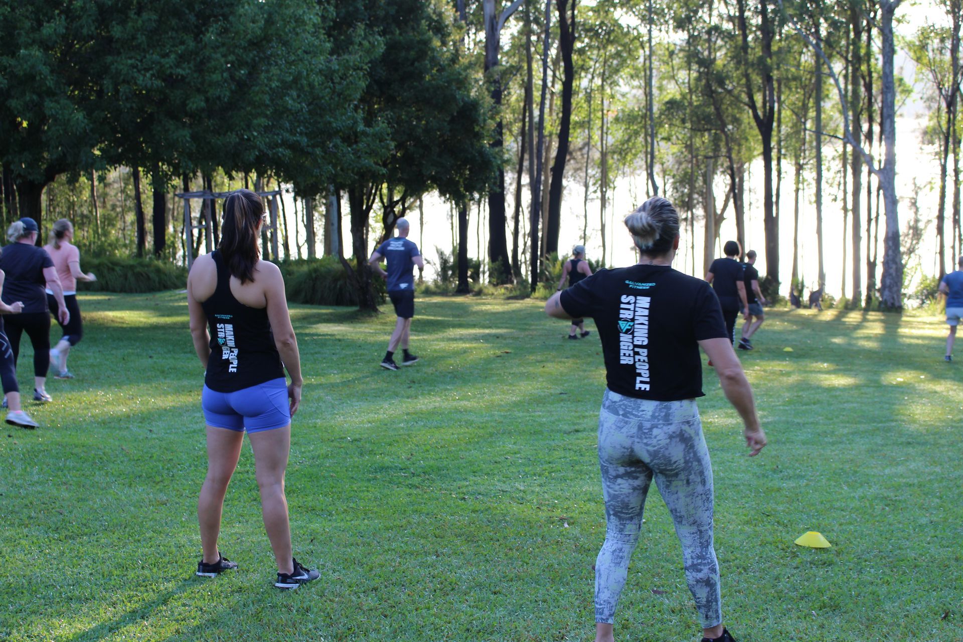 A group of people are doing exercises in a park.