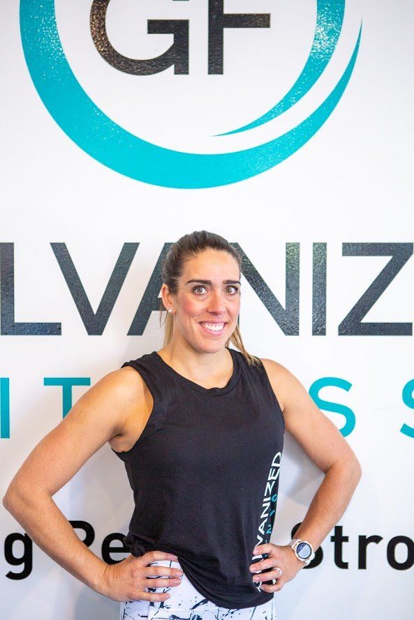 A woman is posing for a picture in front of a sign that says lvaniz