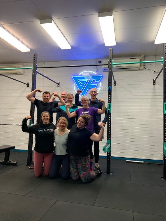 A group of people are posing for a picture in a gym.