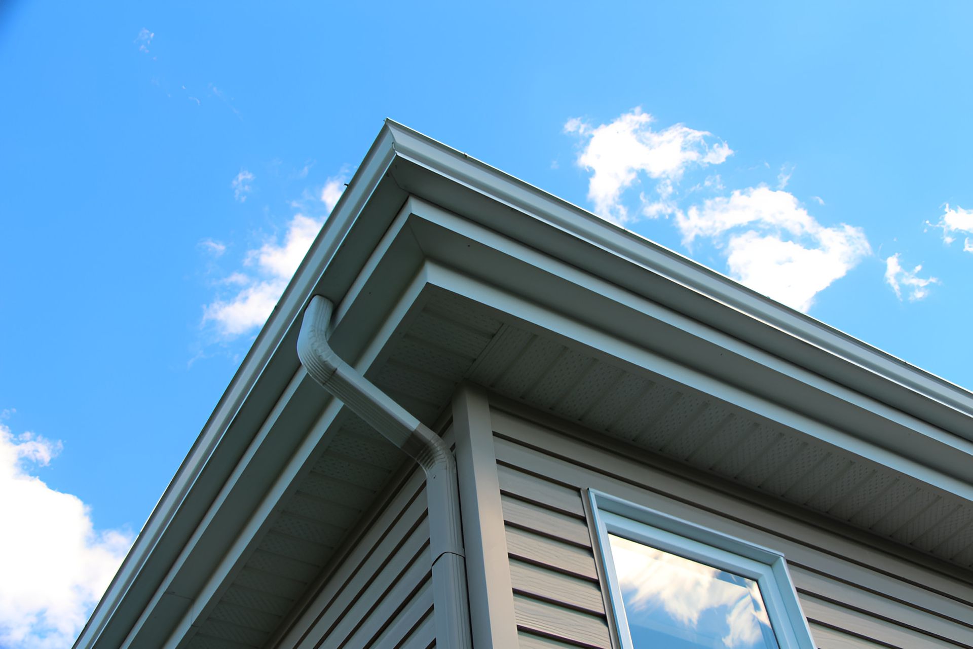 Corner of a gray house with white trim against a blue sky with clouds: Plumber Dubbo -GPS Plumbing