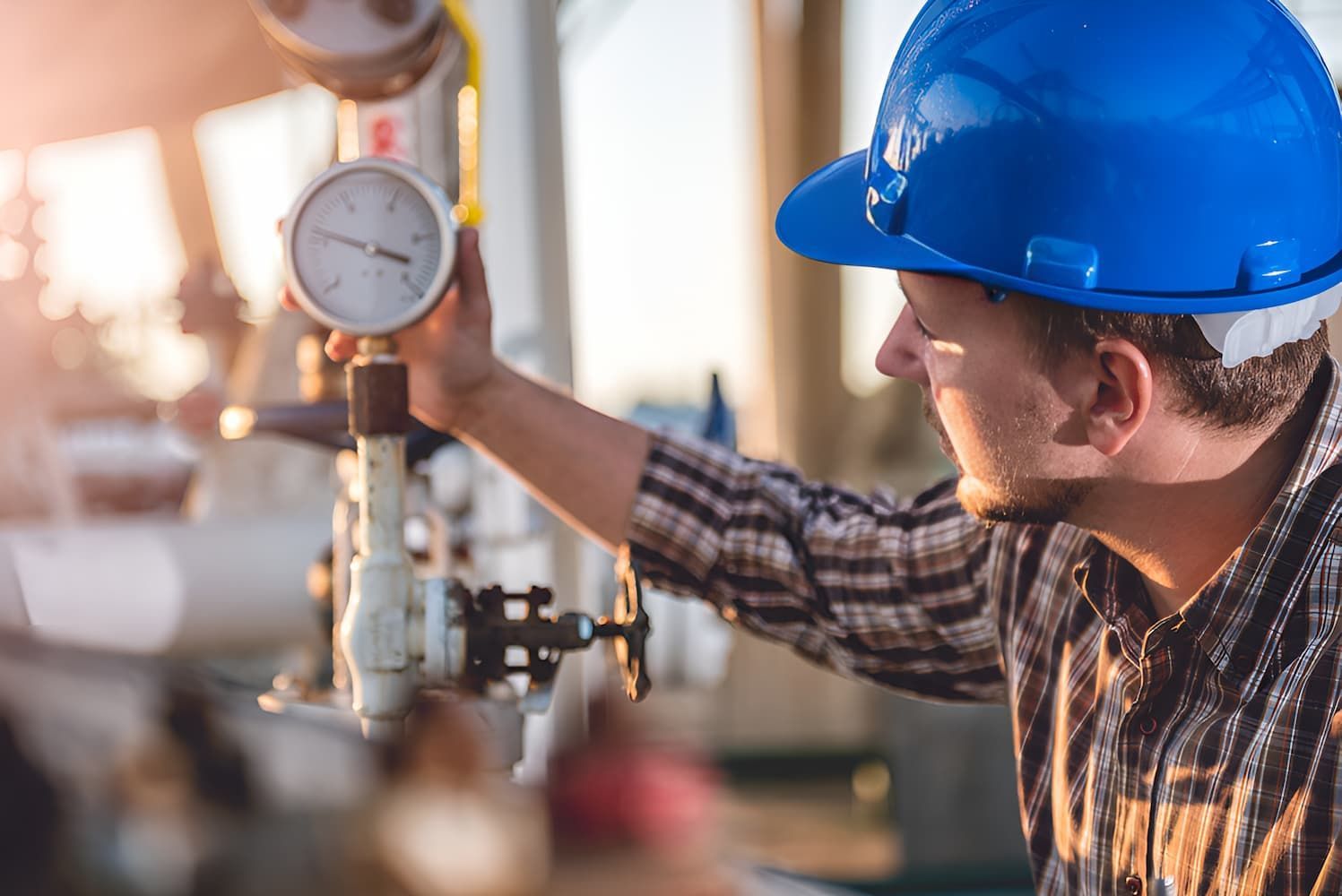 A Man Is Holding A Pressure Gauge — GPS Plumbing, Drainage & Gasfitting In Narromine, NSW
