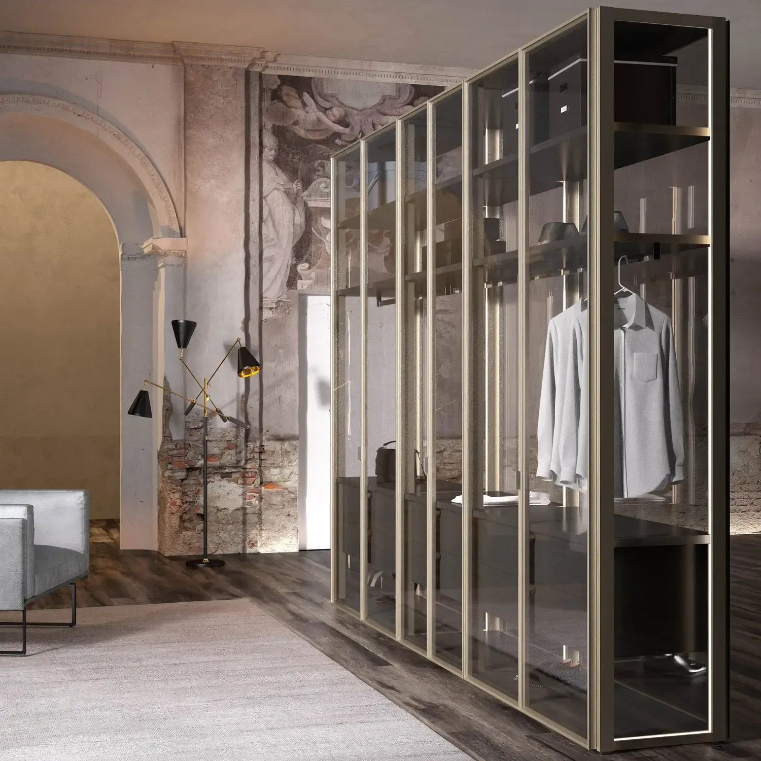 Moderna cabina armadio con ante in vetro e vestiti appesi all'interno contro una parete anticata.