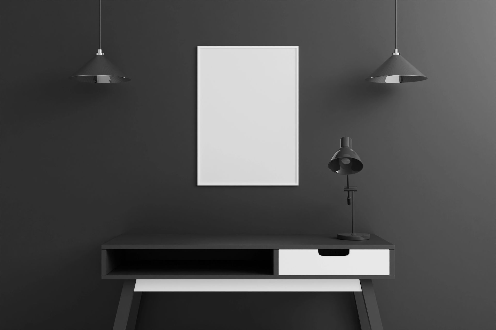 Scrivania nera con un cassetto bianco, un poster vuoto e due lampade sospese su una parete scura.