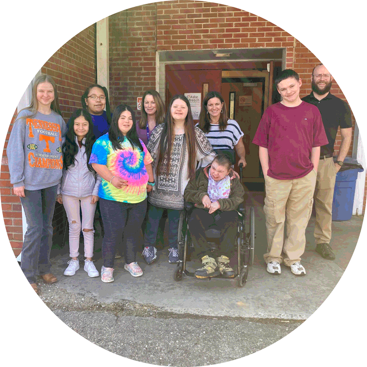 A group of people are posing for a picture in front of a brick building