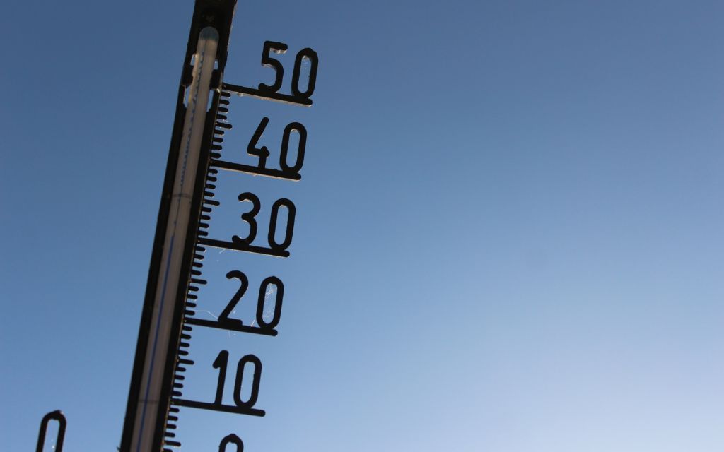 Thermometer against a blue sky, showing temperature marks from 10 to 50.