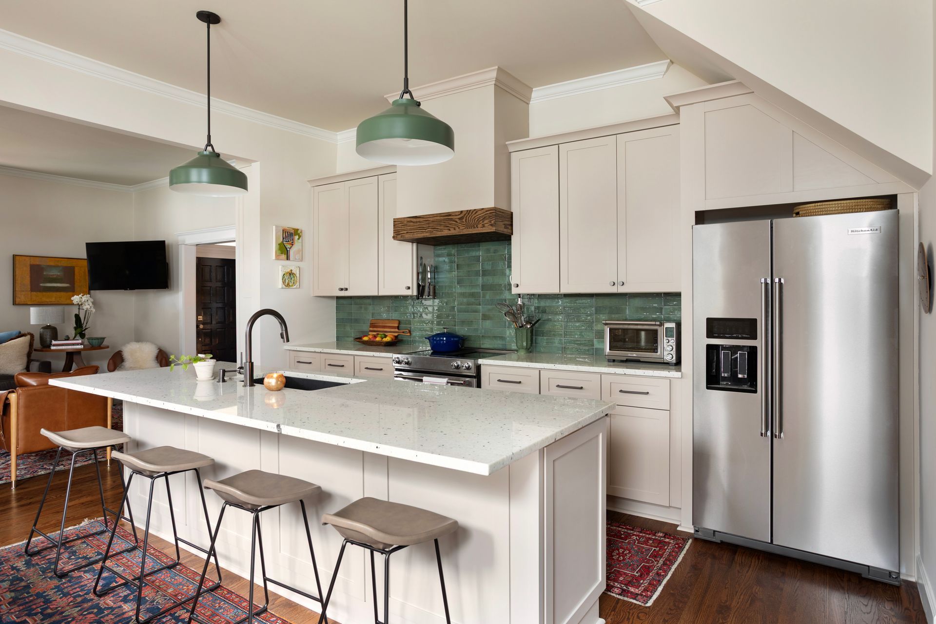Modern kitchen sink under a tall window, with green walls and a blue-tiled countertop