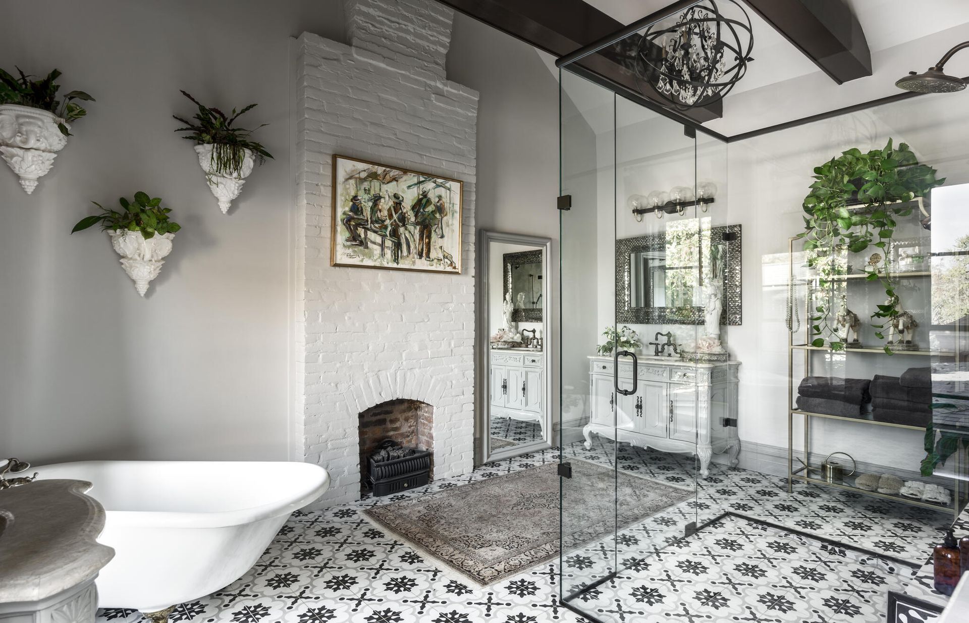 Bright modern bathroom with white tub, glass shower, patterned tile floor, and hanging plants