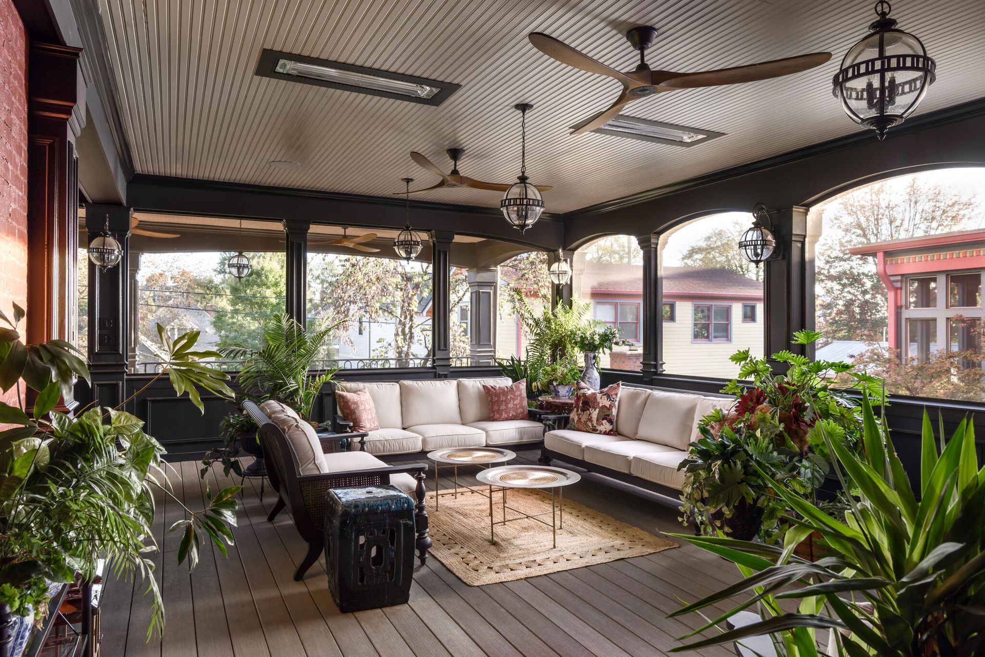 Bright living room with white curtains, wicker chairs, and an open doorway to a sunny patio.
