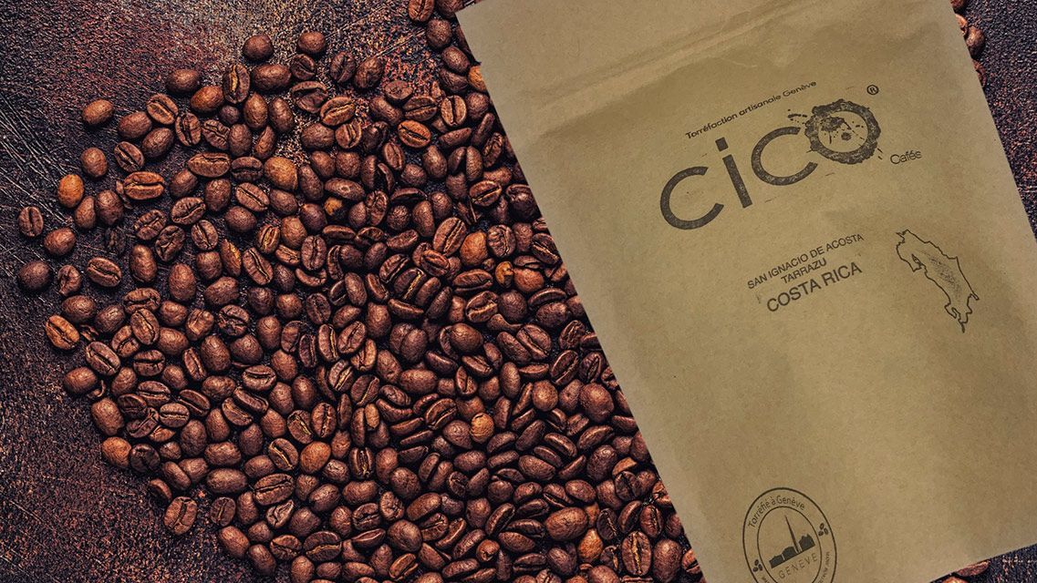 Des grains de café éparpillés à côté d'un sac en papier brun étiqueté « cico » contenant des grains de café.