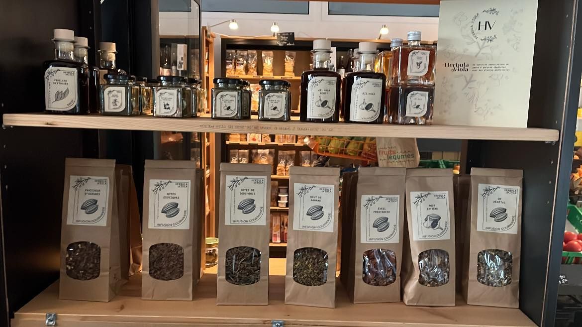 Présentoir avec bocaux et sachets de produits. Emballages en papier kraft, étiquettes diverses, étagères en bois.