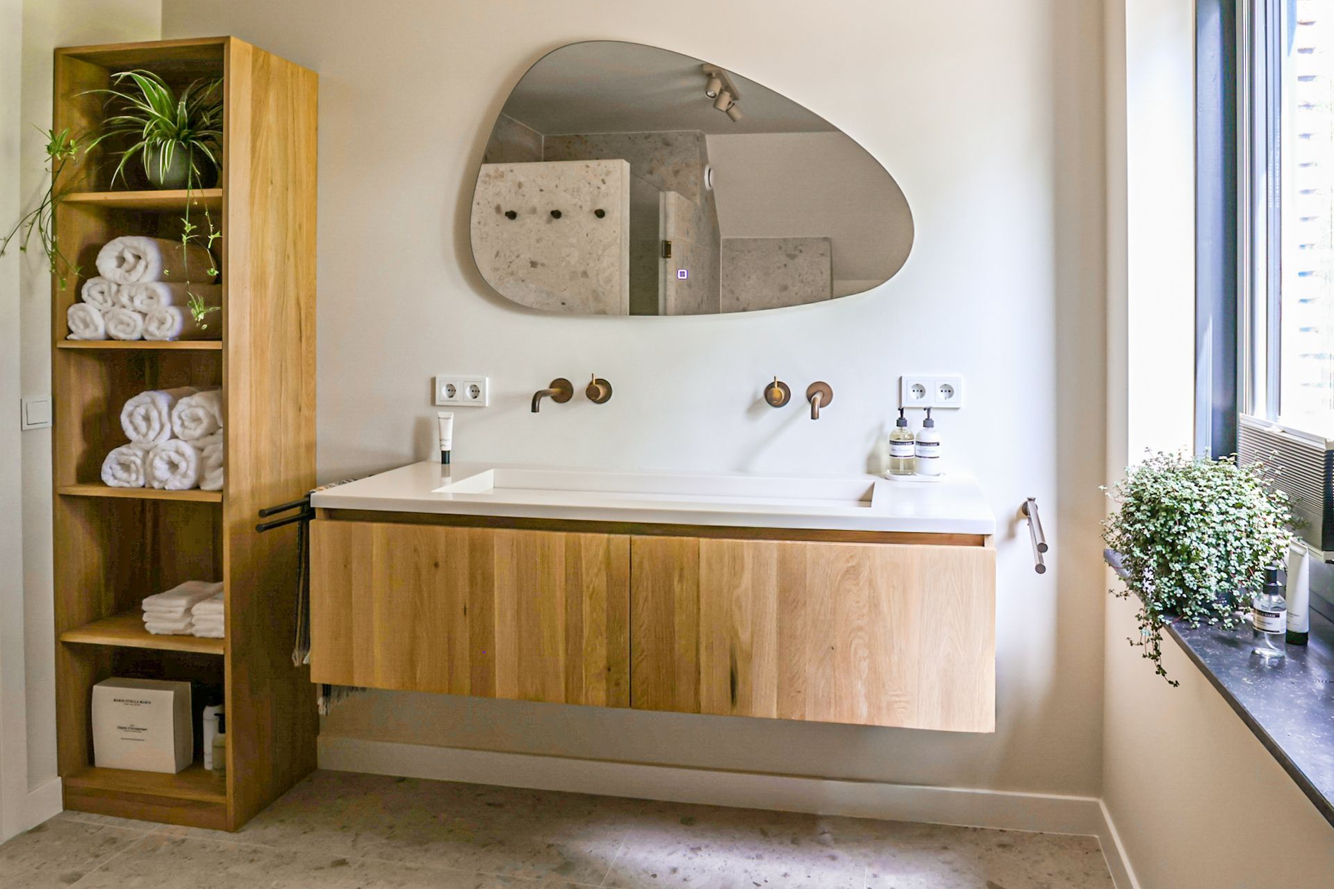 Een moderne woonkamer met maar liefst ruimte voor 3 royale banken. In beige en zwart, en een zwarte sofa, een houten salontafel, een hoogpolig vloerkleed en  grote ramen van vloer tot plafond, die toegang geven tot het zeer grote balkon.