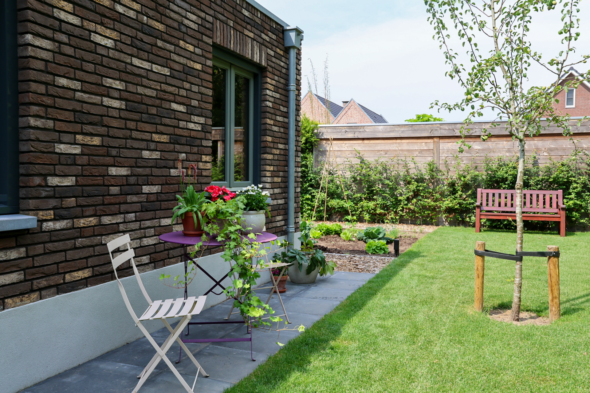 Een moderne woonkamer met maar liefst ruimte voor 3 royale banken. In beige en zwart, en een zwarte sofa, een houten salontafel, een hoogpolig vloerkleed en  grote ramen van vloer tot plafond, die toegang geven tot het zeer grote balkon.
