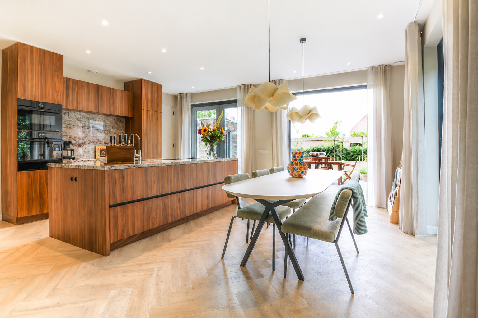 Ruime kamer met een lange houten eettafel, zwarte stoelen, een grote kast en prachtige kamerplanten in een modern penthouse.