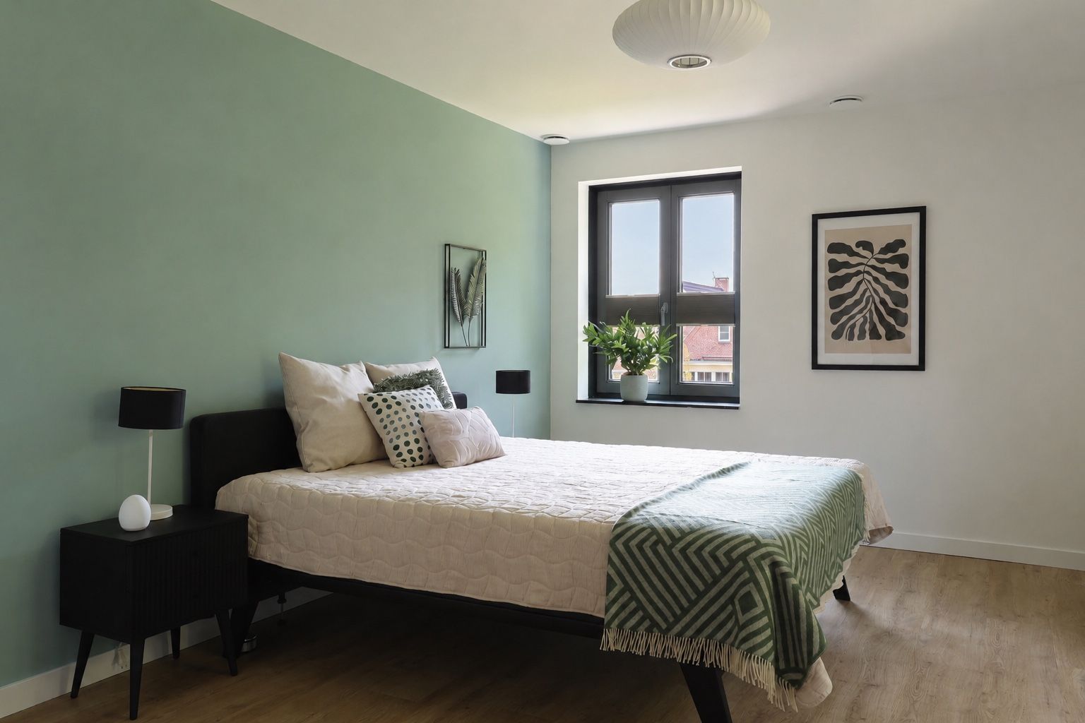 Na restyling, een moderne, minimalistische slaapkamer met een wit bed, grijze muren, een groot raam met uitzicht de tuin. De gekleurde kussen geven sfeer aan deze kamer.