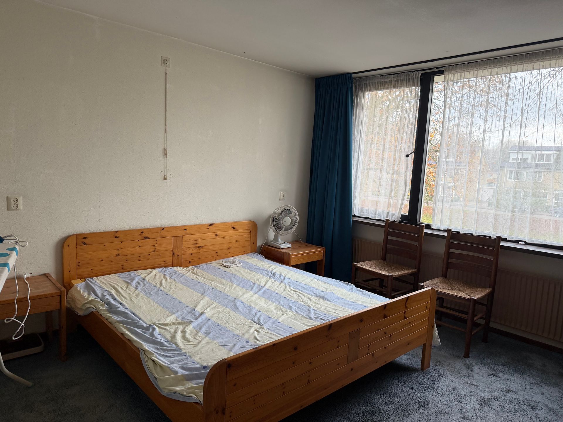 Masterbedroom, die ook dienst doet als strijker. Kamer oogt oudbollig en ongezellig.