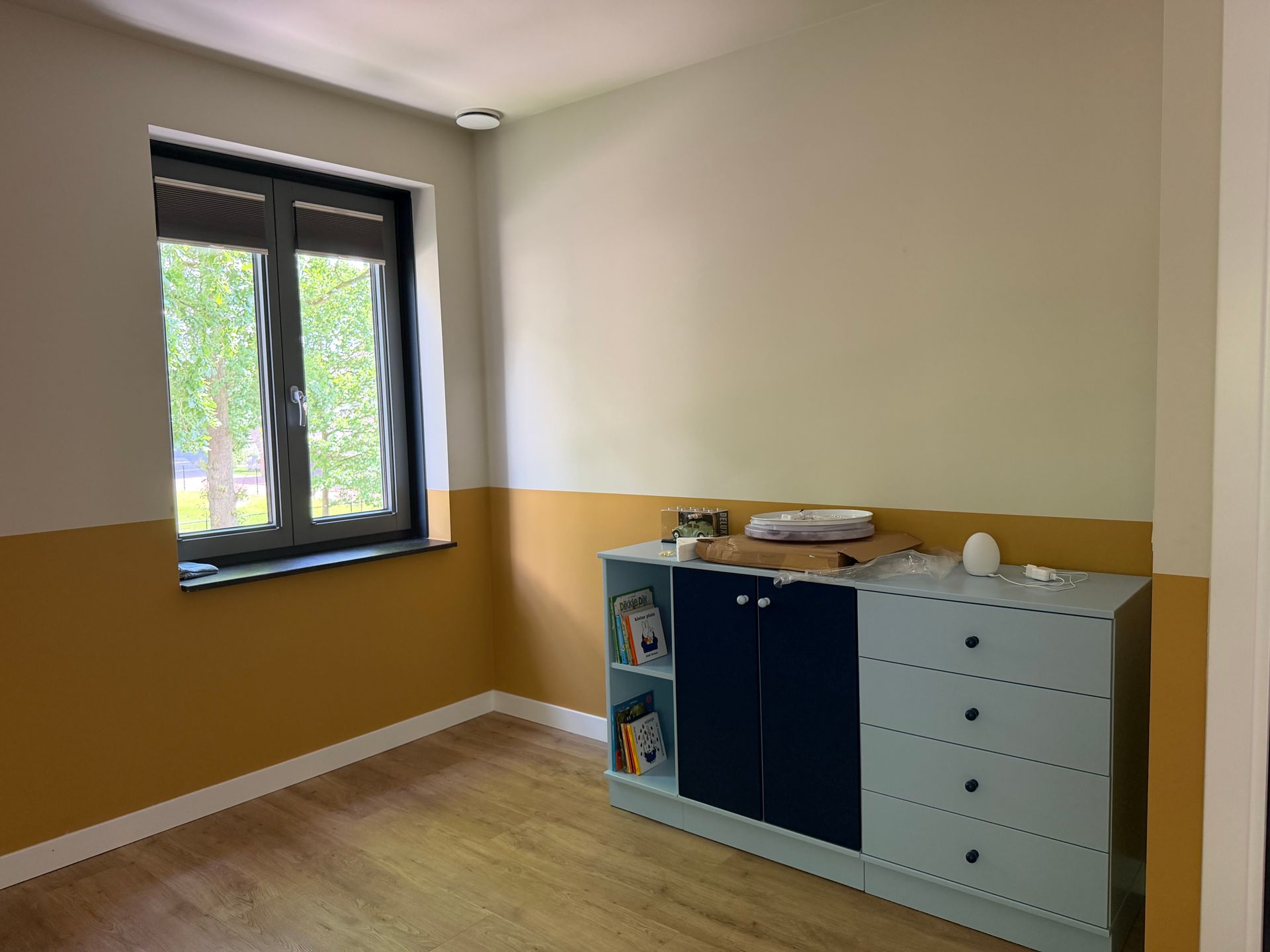 Slaapkamer vooraf gaand aan styling. Raampartijen zijn niet goed zichtbaar, looproutes naar het raam niet vrij. Bed, niet strak opgemaakt.