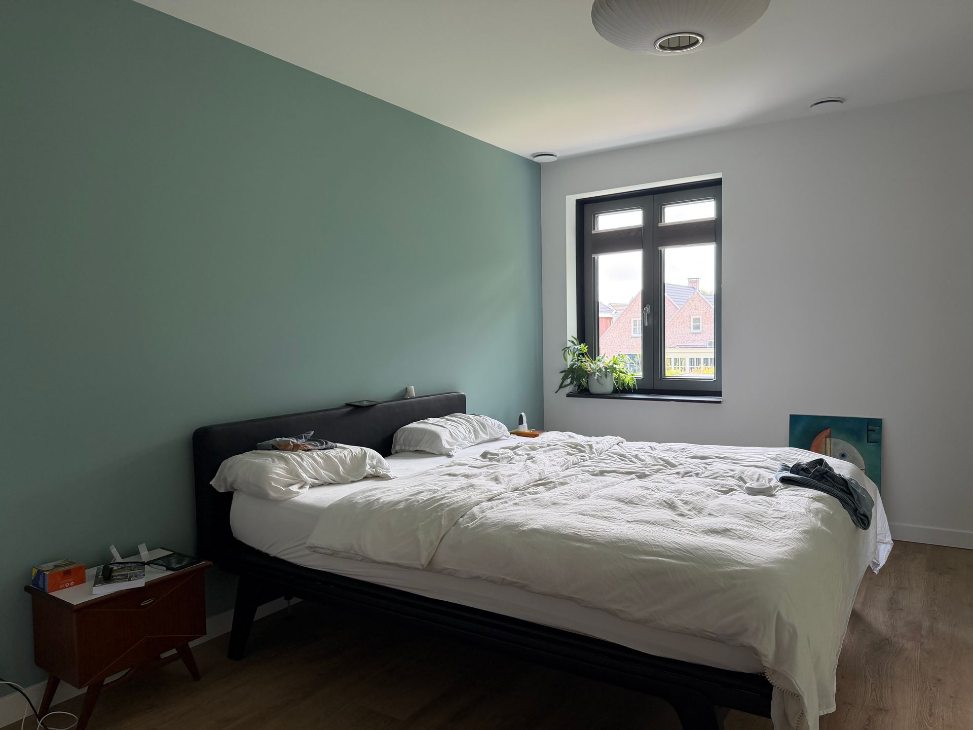 Slaapkamer vooraf gaand aan styling. Raampartijen zijn niet goed zichtbaar, looproutes naar het raam niet vrij. Bed, niet strak opgemaakt.