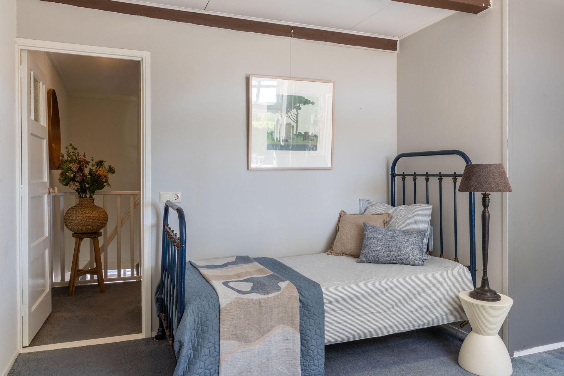 Een moderne woonkamer met maar liefst ruimte voor 3 royale banken. In beige en zwart, en een zwarte sofa, een houten salontafel, een hoogpolig vloerkleed en grote ramen van vloer tot plafond, die toegang geven tot het zeer grote balkon.