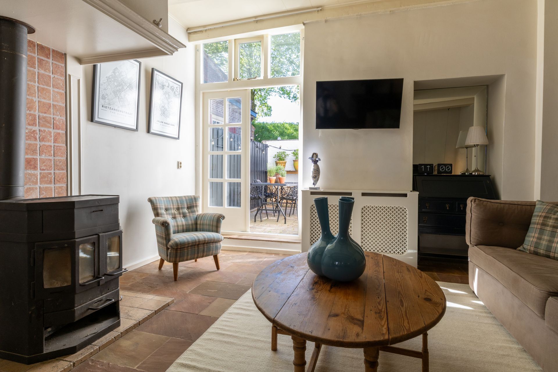 Ruime kamer met een lange houten eettafel, zwarte stoelen, een grote kast en prachtige kamerplanten in een modern penthouse.