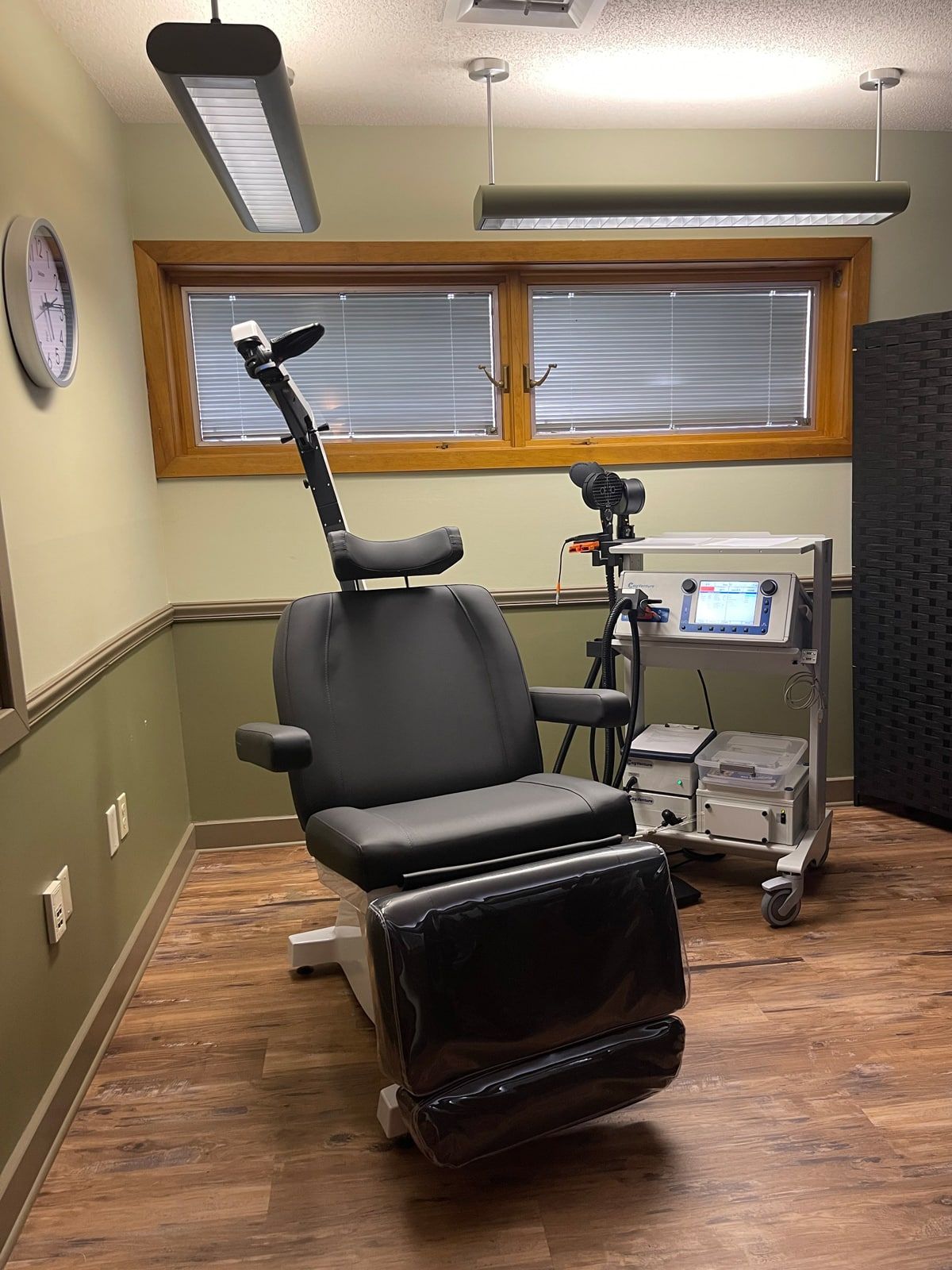 a room with a tms clinic chair and a clock on the wall located in carbondale Illinois