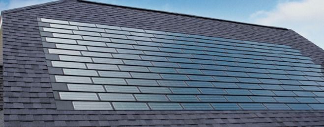 Sloped roof with dark gray and blue solar panels in neat rows