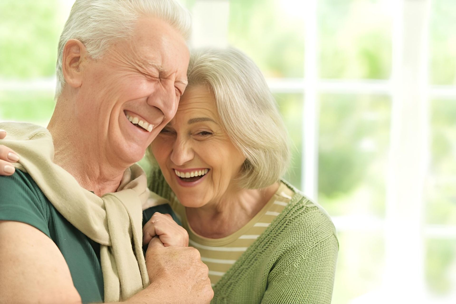 An Elderly Couple is Laughing Together and Hugging Each Other — Active Lifestyle Supports In Tullimbar, NSW