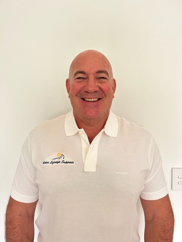 A Man is smiling for the camera in a white polo shirt — Active Lifestyle Supports In Tullimbar, NSW