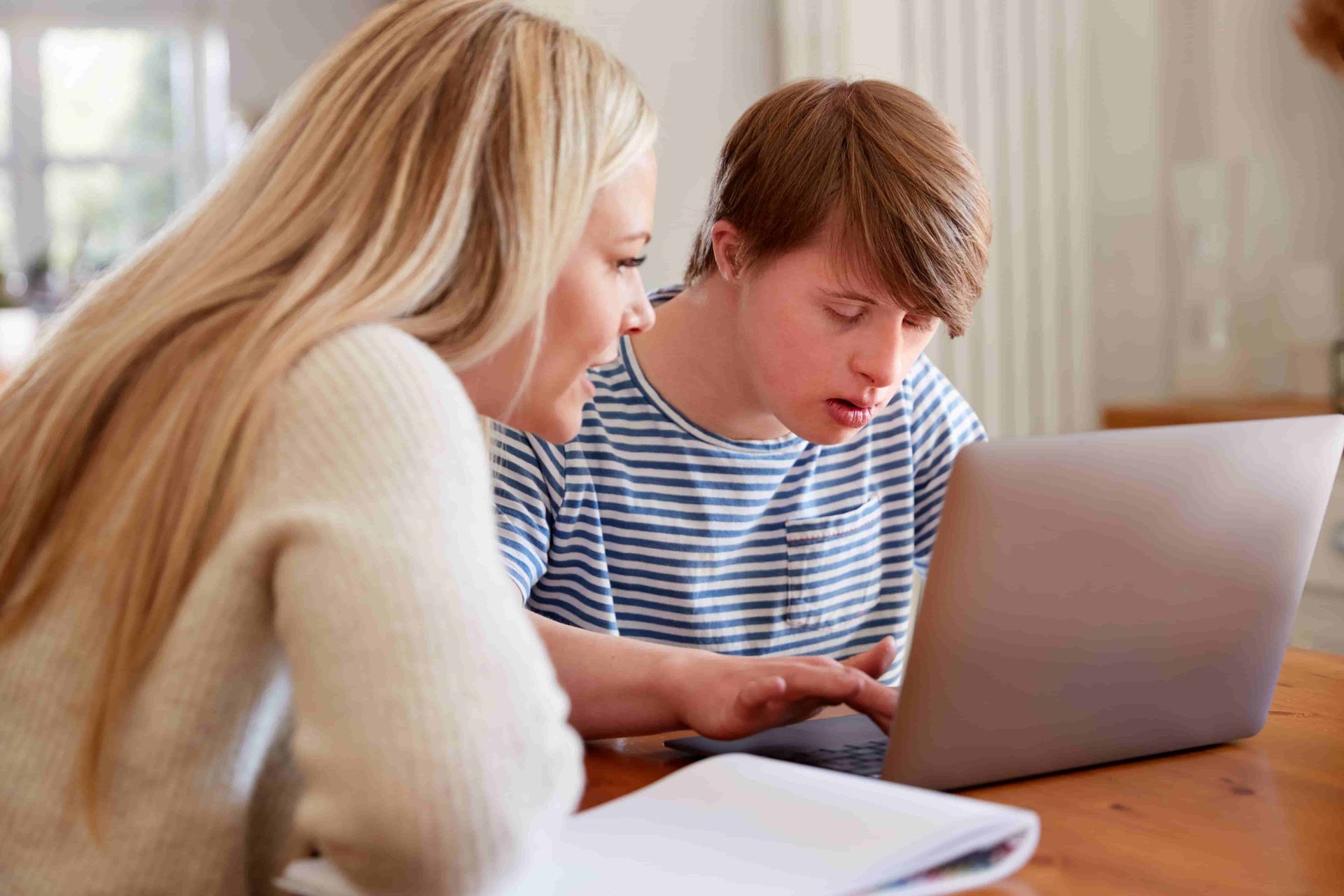 Woman Helping Child With Downs Syndrome Do His Homework — Active Lifestyle Supports In Tullimbar, NSW
