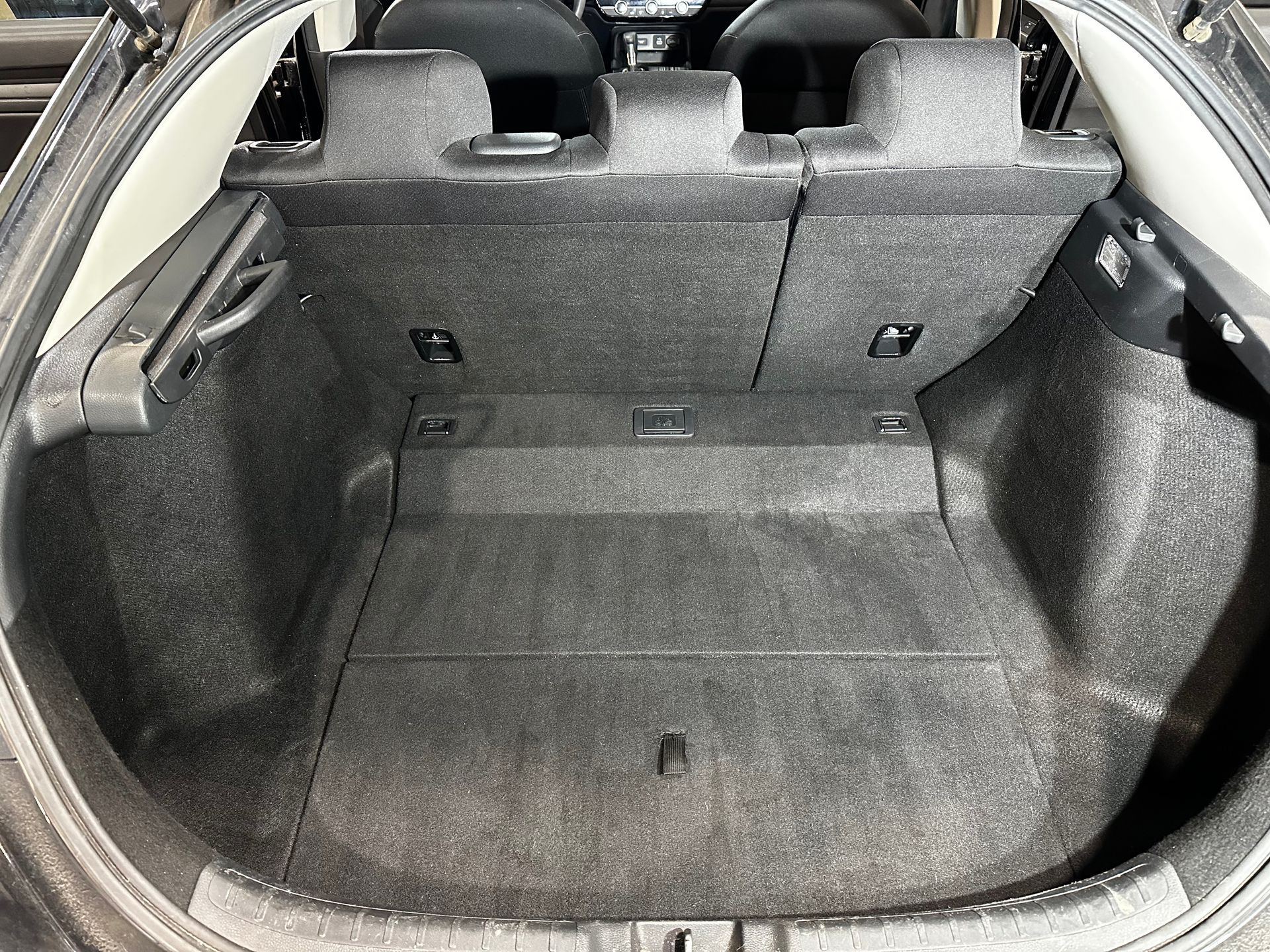 Car trunk with gray carpeted cargo area and rear seats folded up