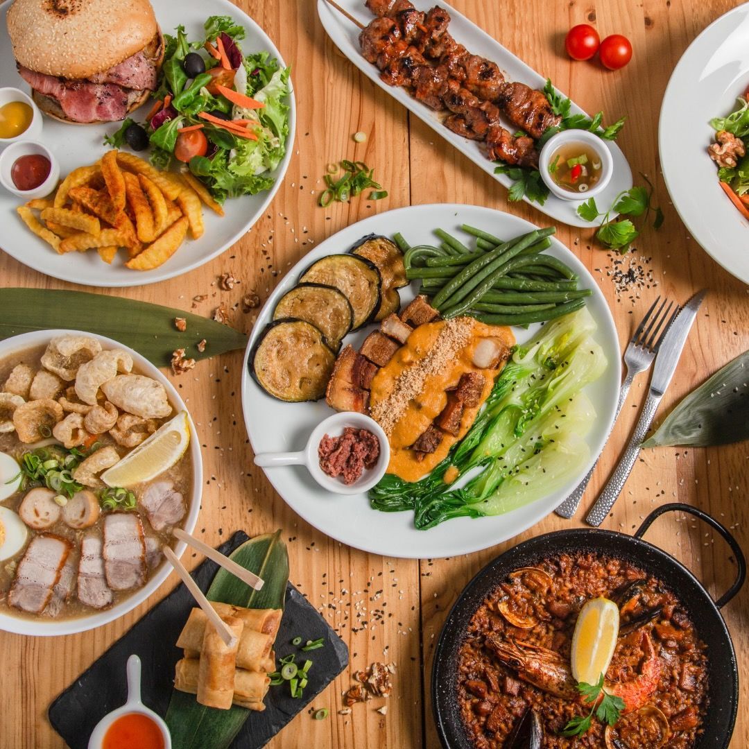 A wooden table topped with plates of food and utensils