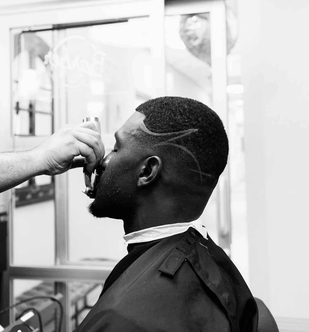 Close-up of a beard being trimmed with scissors by hand
