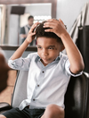 child getting a haircut in a barber shop