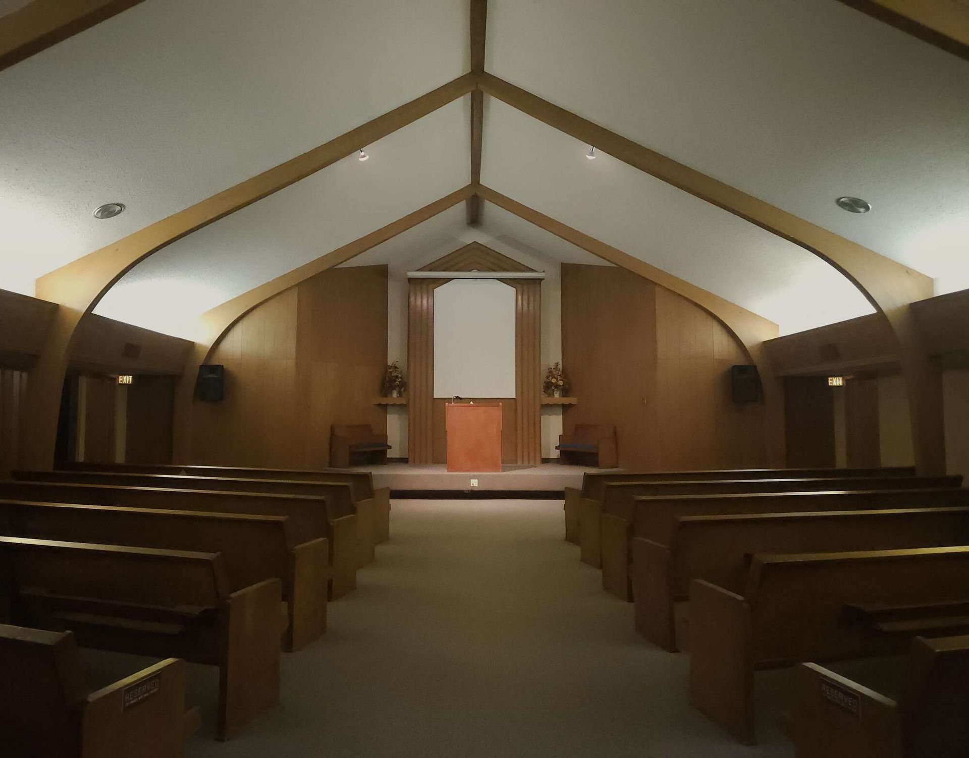 A man in a suit is sitting at a coffin at a funeral.