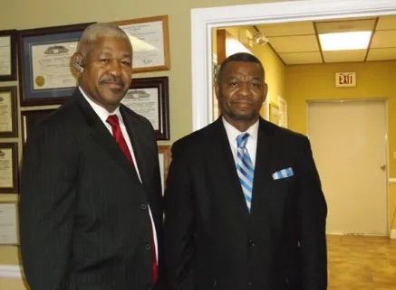 Two men in suits at Wolfe Brothers Funeral Home.