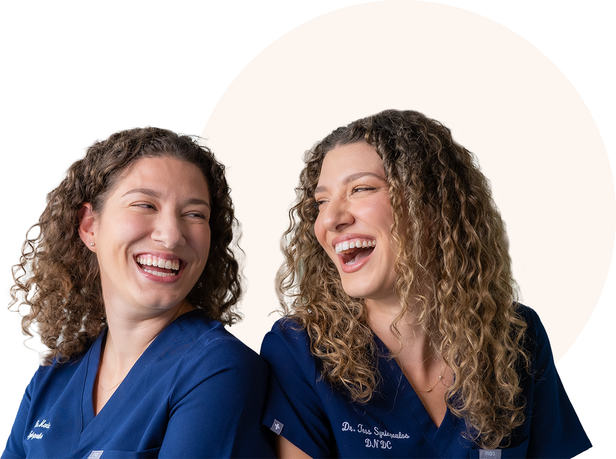 Two women are standing next to each other and laughing.