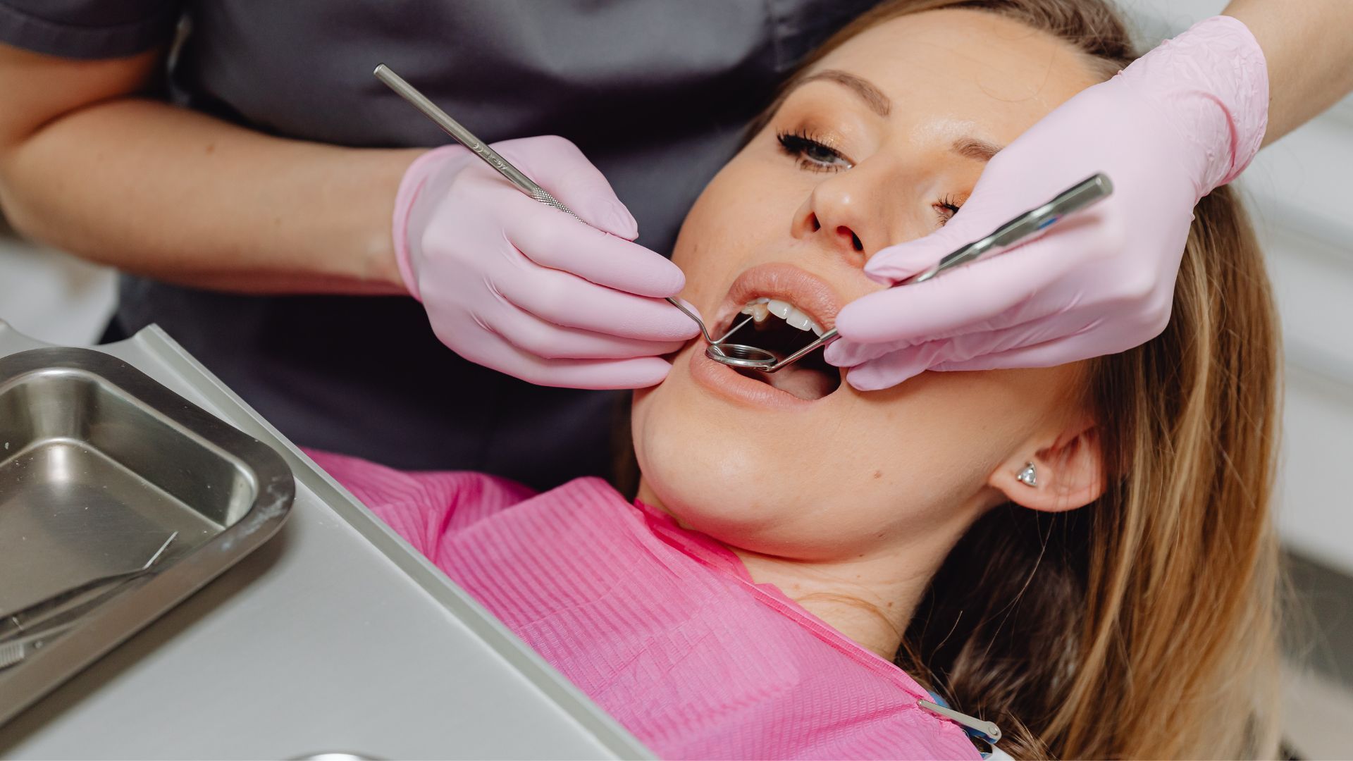 Dentist and assistant in dental office with a laughing patient.