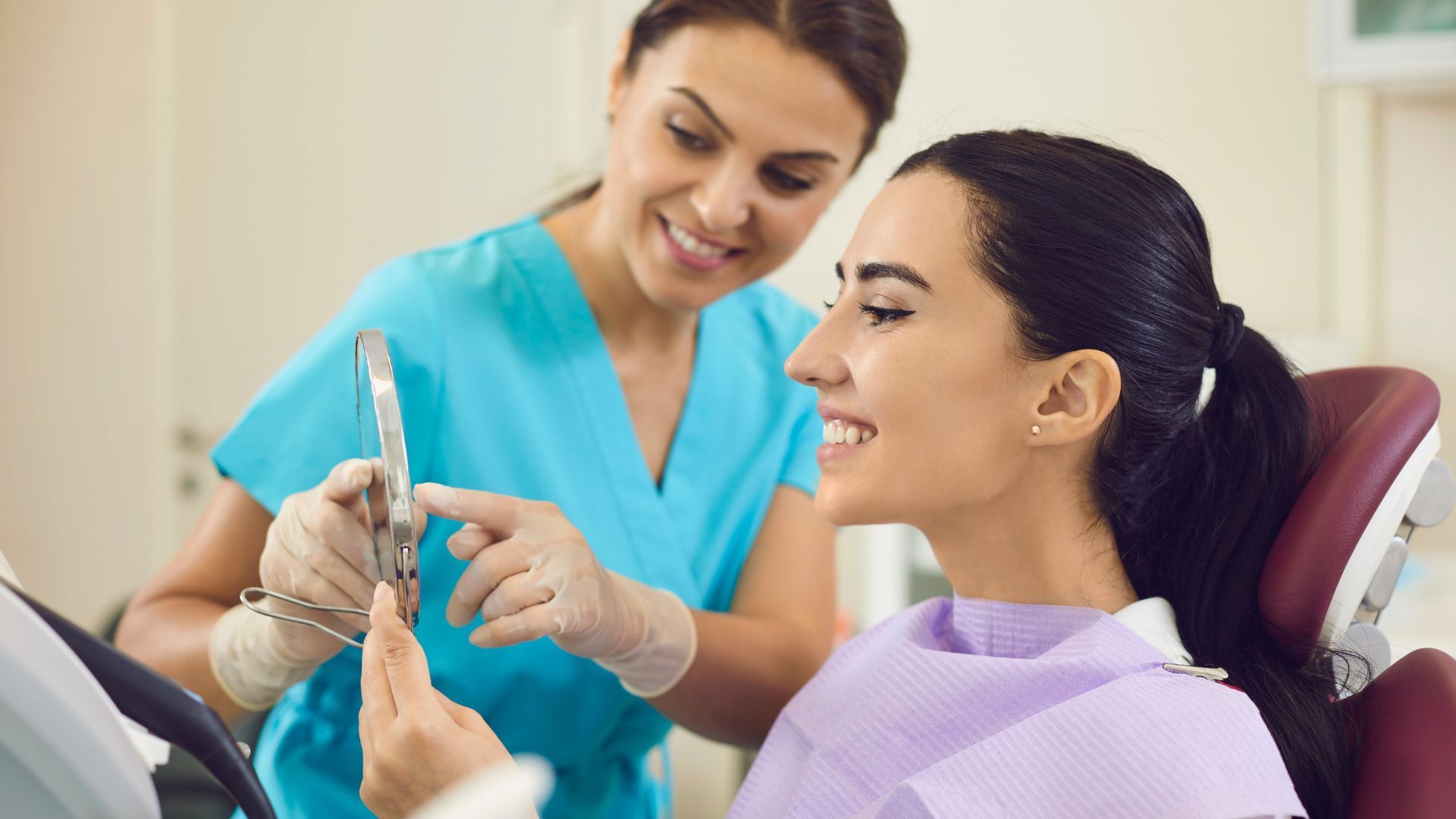 Dentist and assistant in dental office with a laughing patient.