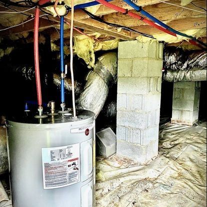 Water heater in crawl space with supply lines, insulation, and support columns.