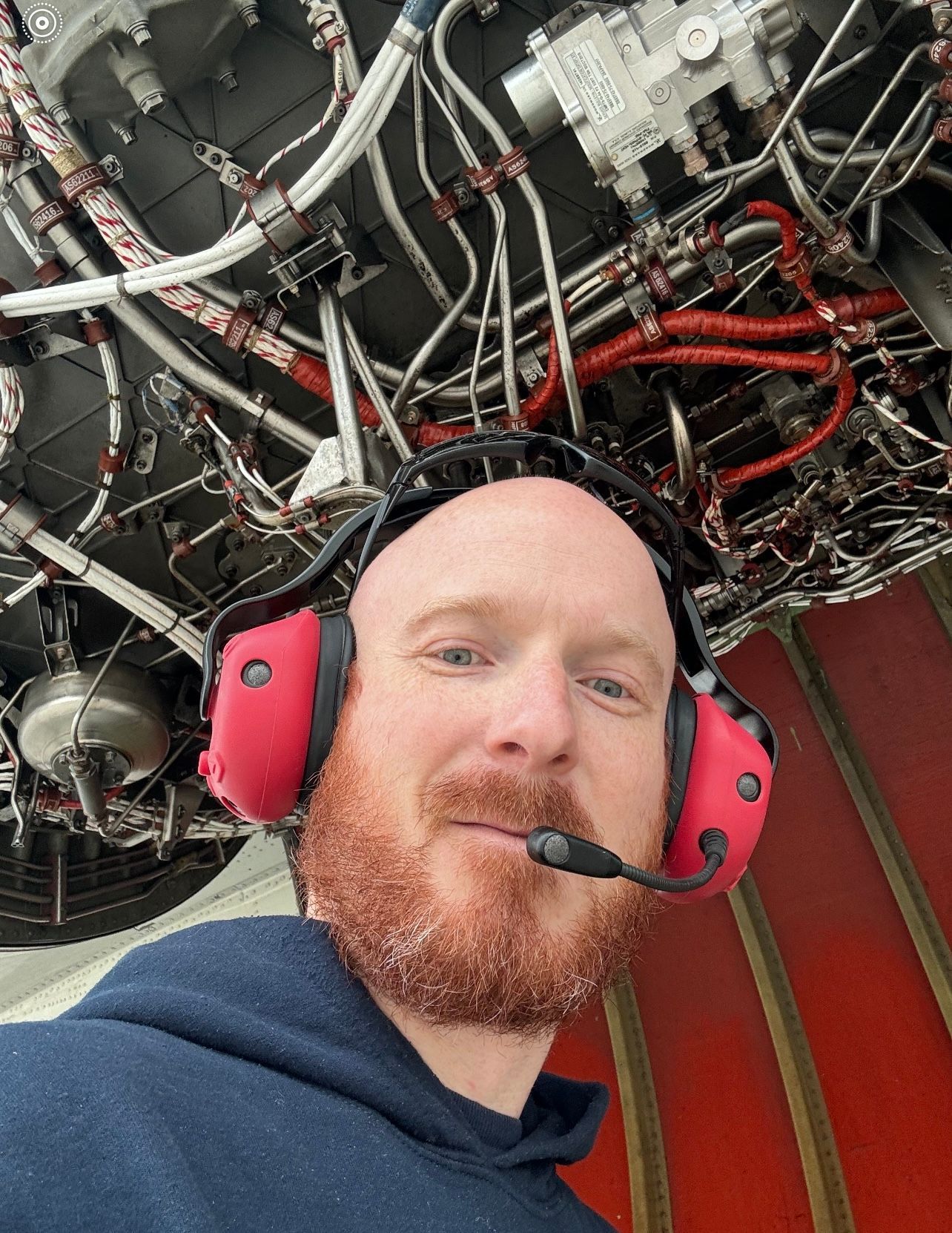 A man with a beard is wearing headphones and a microphone.