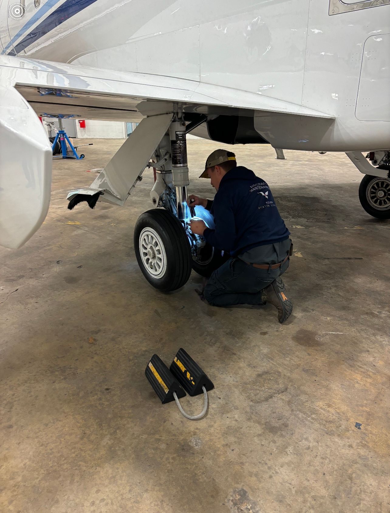 A man is working on a plane in a hangar.
