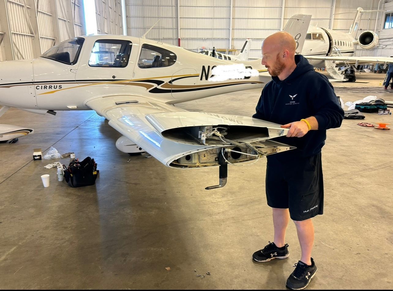 A man is working on an airplane in a hangar.