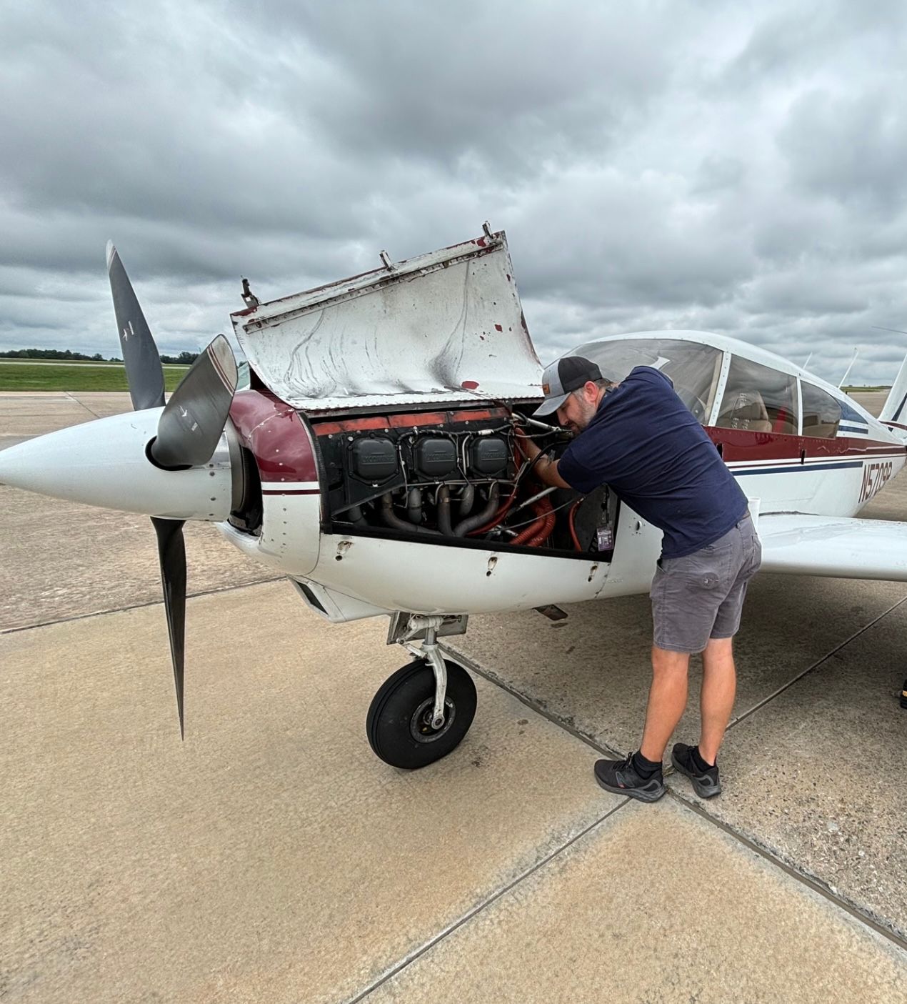 A man is working on the engine of a small plane.